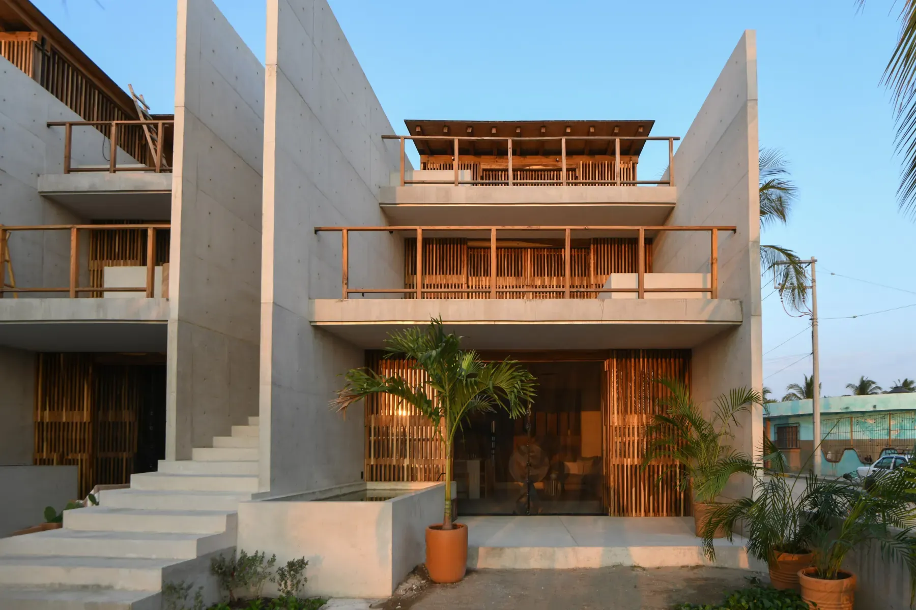 Fachada de Paxifico con muros de concreto, celosías de madera y terrazas